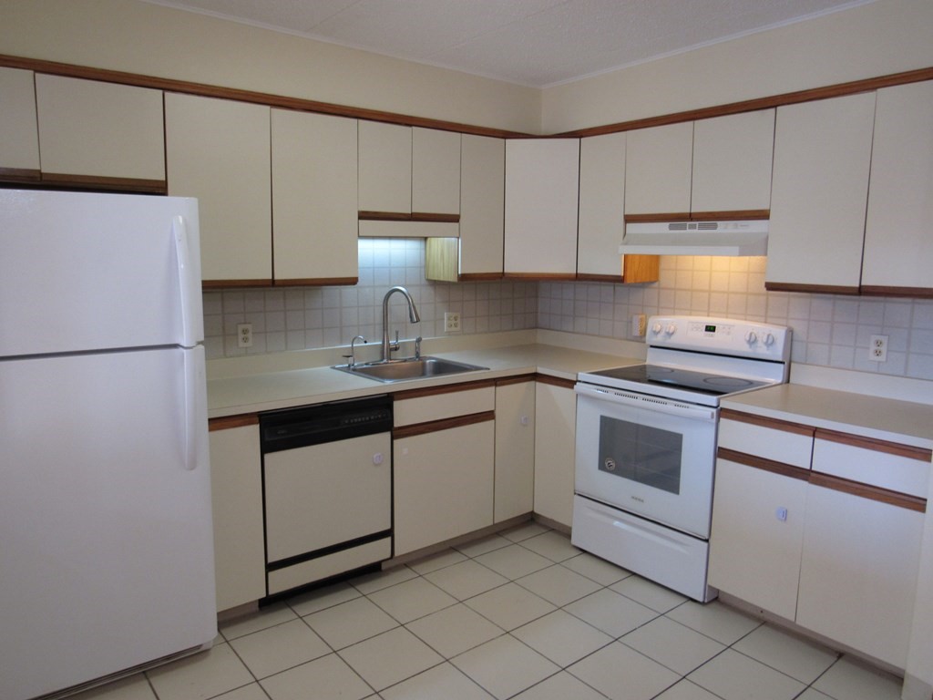 8 Nahant Place, Unit 202 Lynn, MA 01902 - Photo 9 of 24 a kitchen with granite countertop white cabinets and white appliances