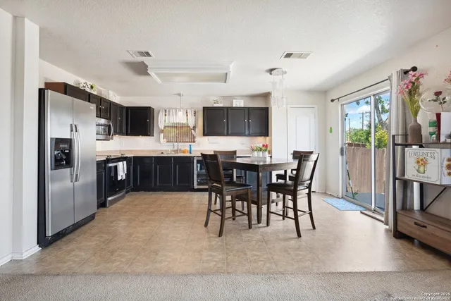 a view of kitchen with microwave stove refrigerator and dining table