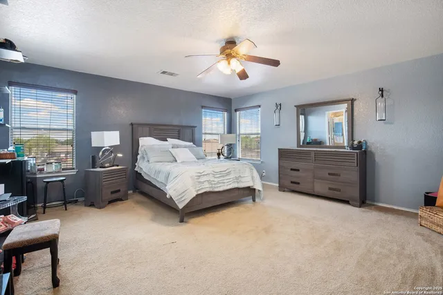 a spacious bedroom with a bed and a chandelier