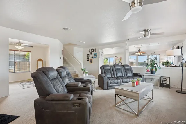a living room with furniture kitchen view and a window