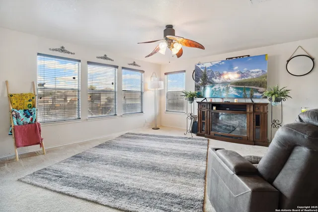 a living room with furniture a floor to ceiling window and a flat screen tv