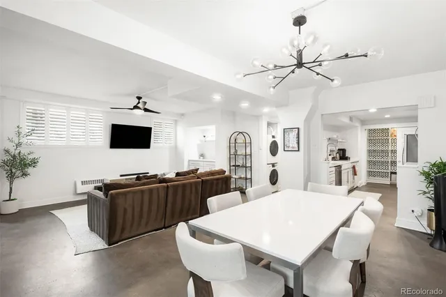 a large kitchen with stainless steel appliances a stove a sink dishwasher a dining table and chairs with wooden floor