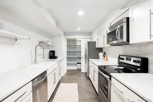 a kitchen with stainless steel appliances a stove a sink and a refrigerator