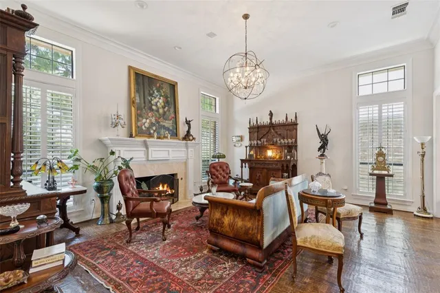 a living room with furniture a chandelier and a fireplace