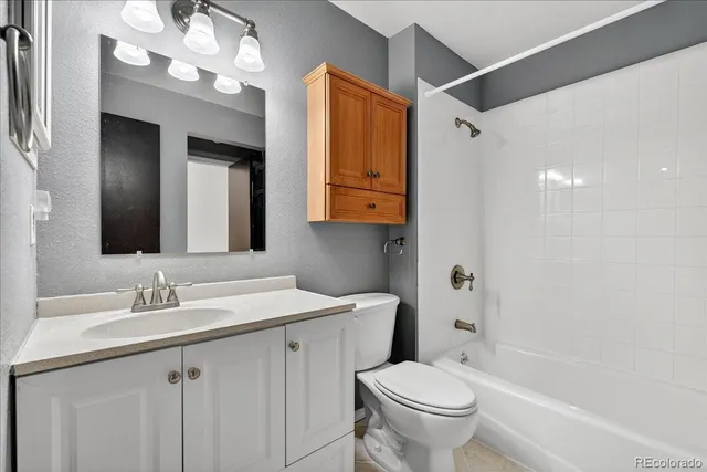a bathroom with a sink a toilet a mirror a vanity and bathtub