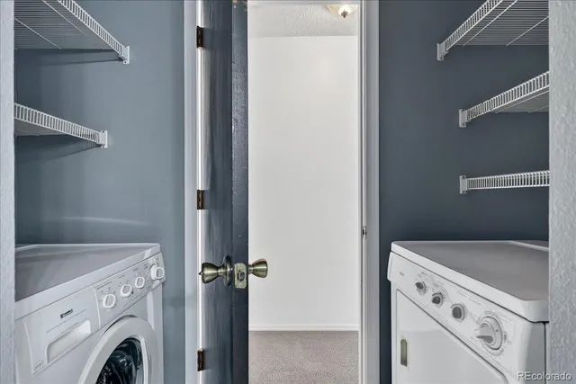 a view of washer and dryer with kitchen in the background