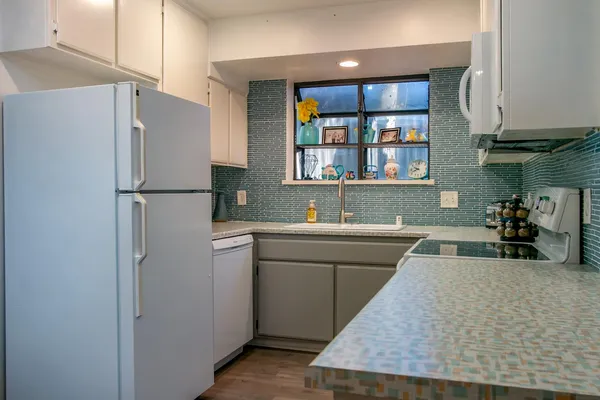 a kitchen with a refrigerator sink and white cabinets