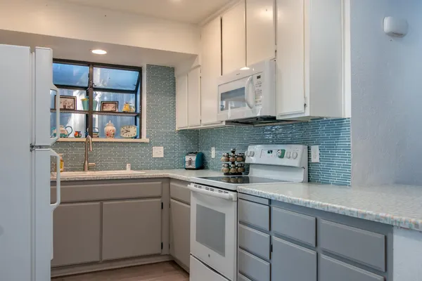 a kitchen with cabinets appliances a sink and a window