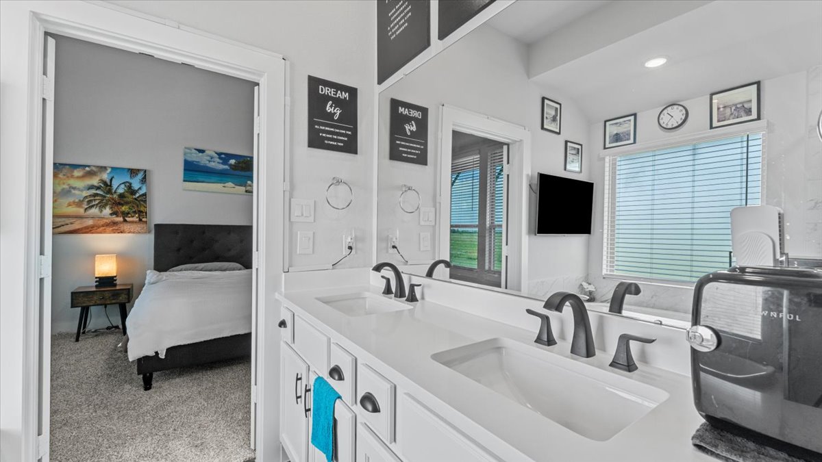 16627 Lake Austin Street Cypress, TX 77433 - Photo 31 of 32 a en suite bathroom with double vanity a mirror and a shower