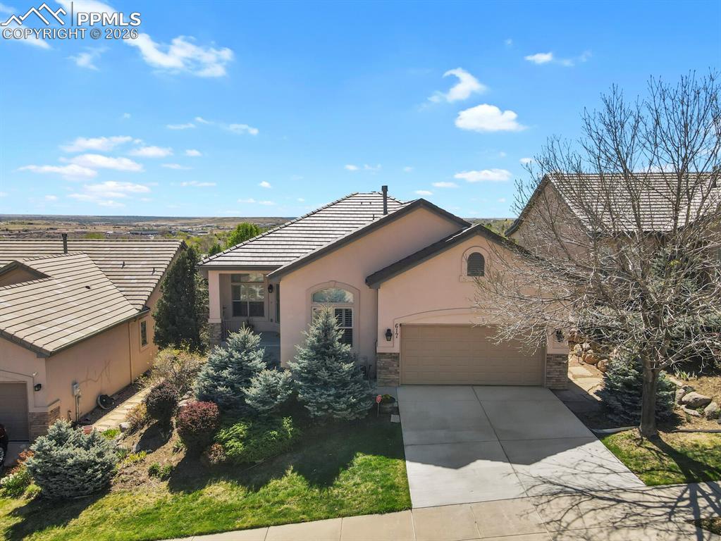 617 Concerto Drive Colorado Springs, CO 80906 - Photo 2 of 46 Aerial view of this stucco ranch with stone accents, a tiled roof, and a concrete driveway w/two car attached garage.