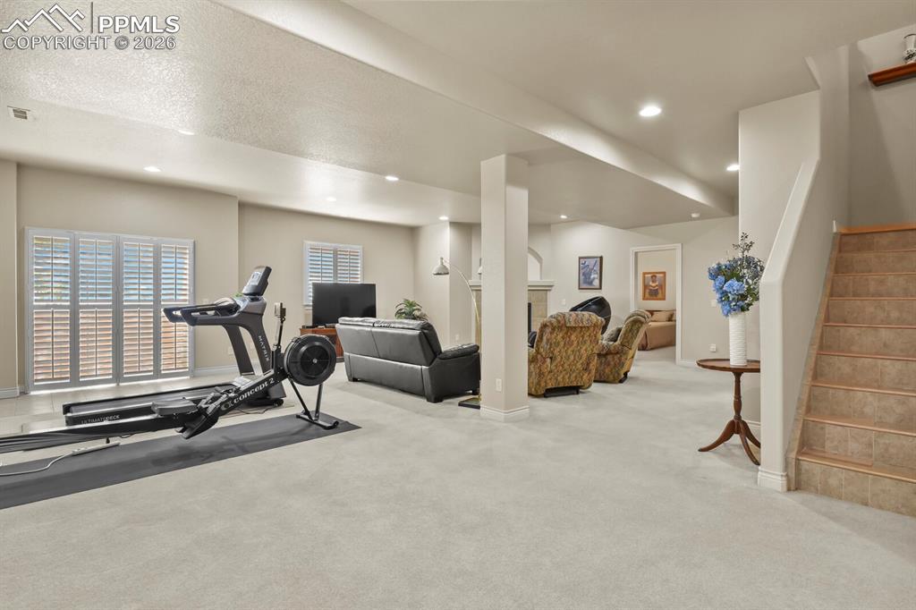 617 Concerto Drive Colorado Springs, CO 80906 - Photo 27 of 46 Spacious Family Room area with walkout to a second covered patio area, recessed lighting, and a staircase with tiled & wood steps