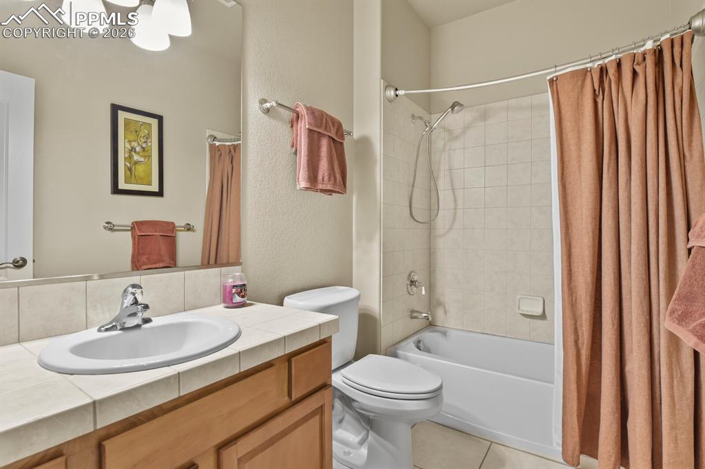 617 Concerto Drive Colorado Springs, CO 80906 - Photo 33 of 46 The basement bathroom features a vanity with a tile countertop and an integrated sink, a toilet, and a bathtub with a tiled surround