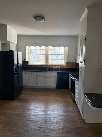 a large kitchen with stainless steel appliances granite countertop a refrigerator and a sink