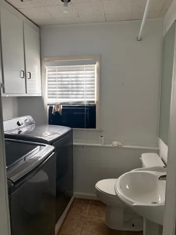 a bathroom with a toilet sink and mirror