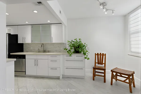 a spacious en suite bathroom with a granite countertop sink and a mirror