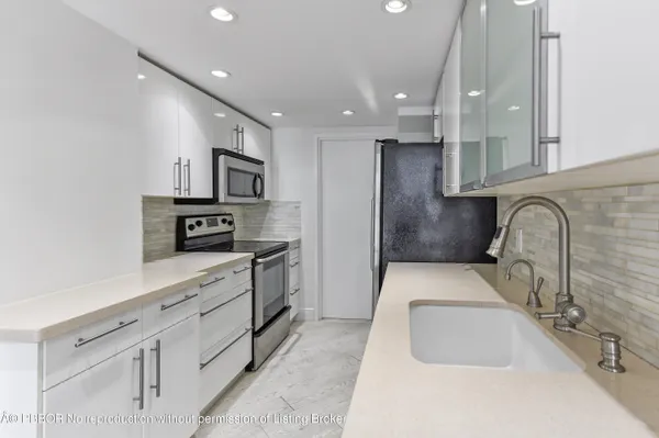 a kitchen with stainless steel appliances sink refrigerator and microwave