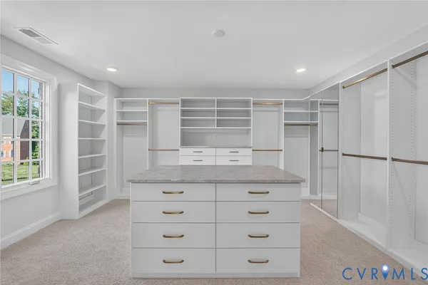 a kitchen with white cabinets and window
