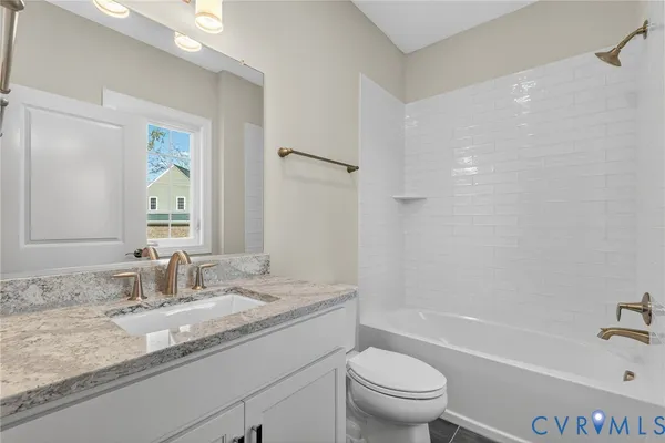 a bathroom with a granite countertop sink a toilet and a bathtub
