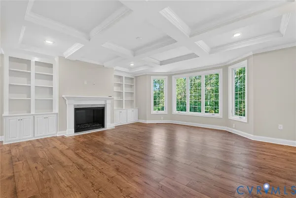 a view of empty room with wooden floor and fireplace