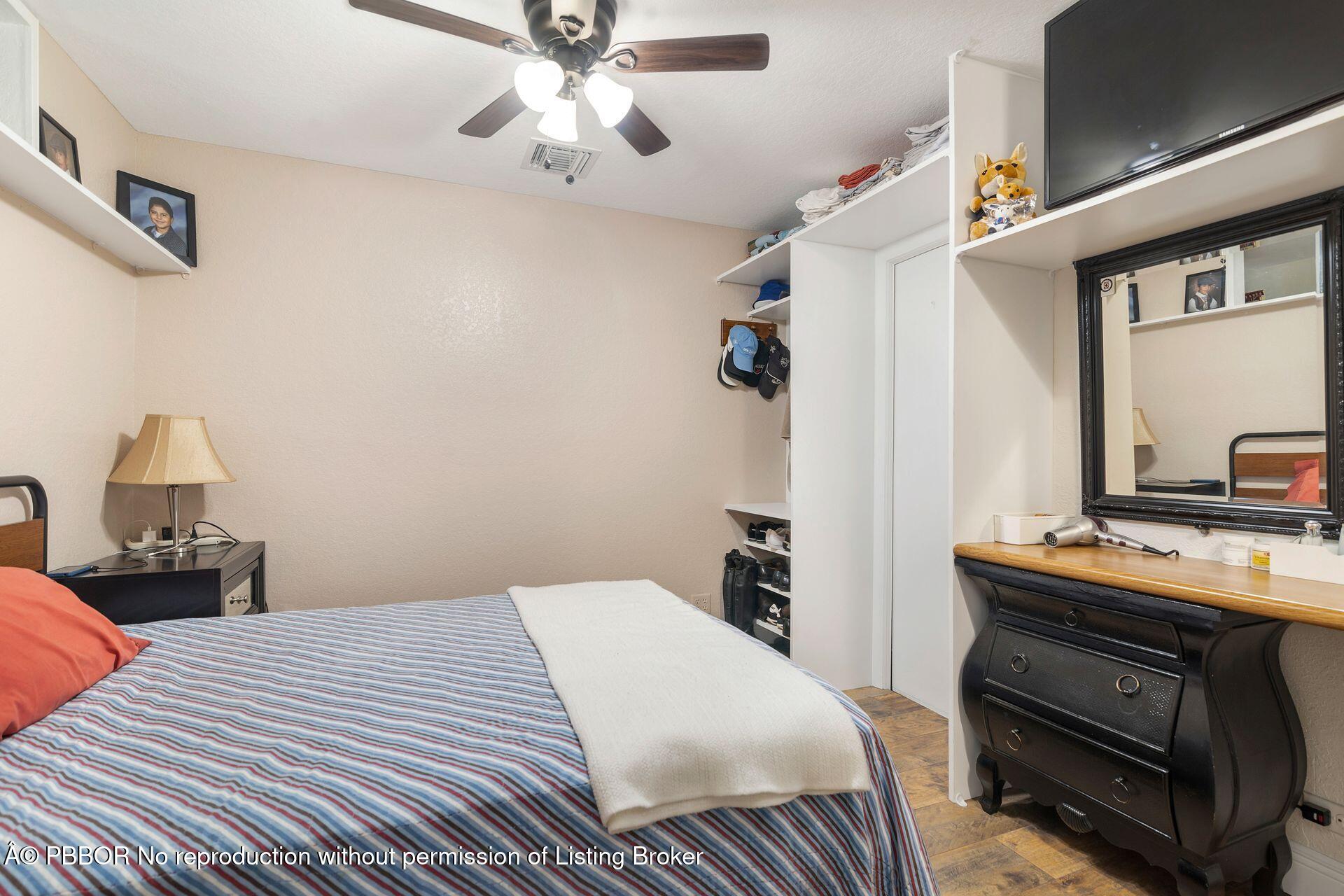 2770 E Road Loxahatchee, FL 33470 - Photo 32 of 51 a bedroom with a bed and a chandelier
