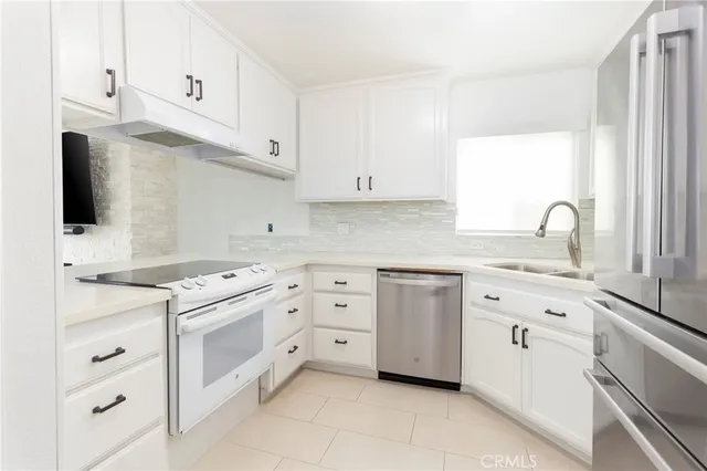 a kitchen with cabinets appliances a sink and a window