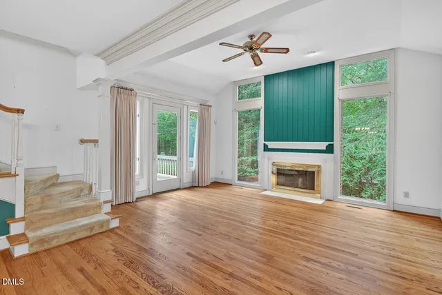 a view of a hallway with wooden floor and staircase