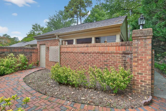 a view of a brick house with plants