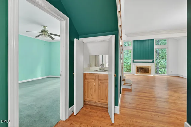a kitchen with white cabinets and wooden floor