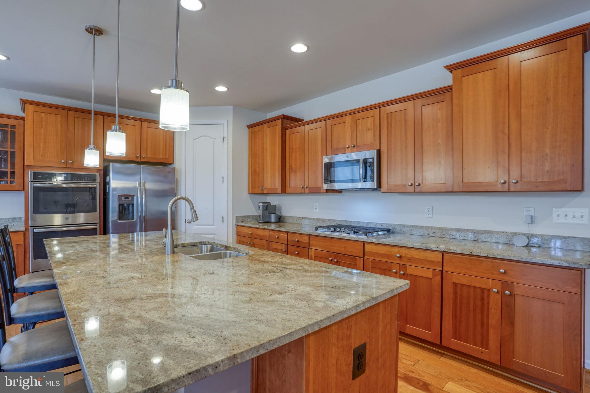 34273 Spring Brook Avenue Lewes, DE 19958 - Photo 11 of 73 a kitchen with kitchen island granite countertop a sink a counter top space appliances and cabinets