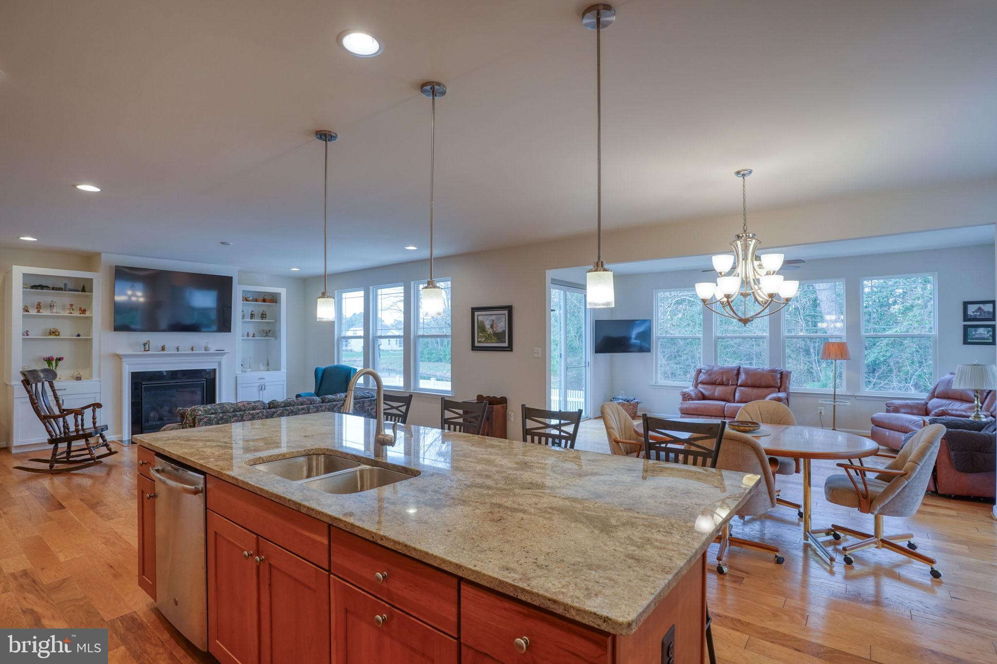34273 Spring Brook Avenue Lewes, DE 19958 - Photo 12 of 73 a kitchen with stainless steel appliances granite countertop a sink dishwasher a dining table and chairs with wooden floor