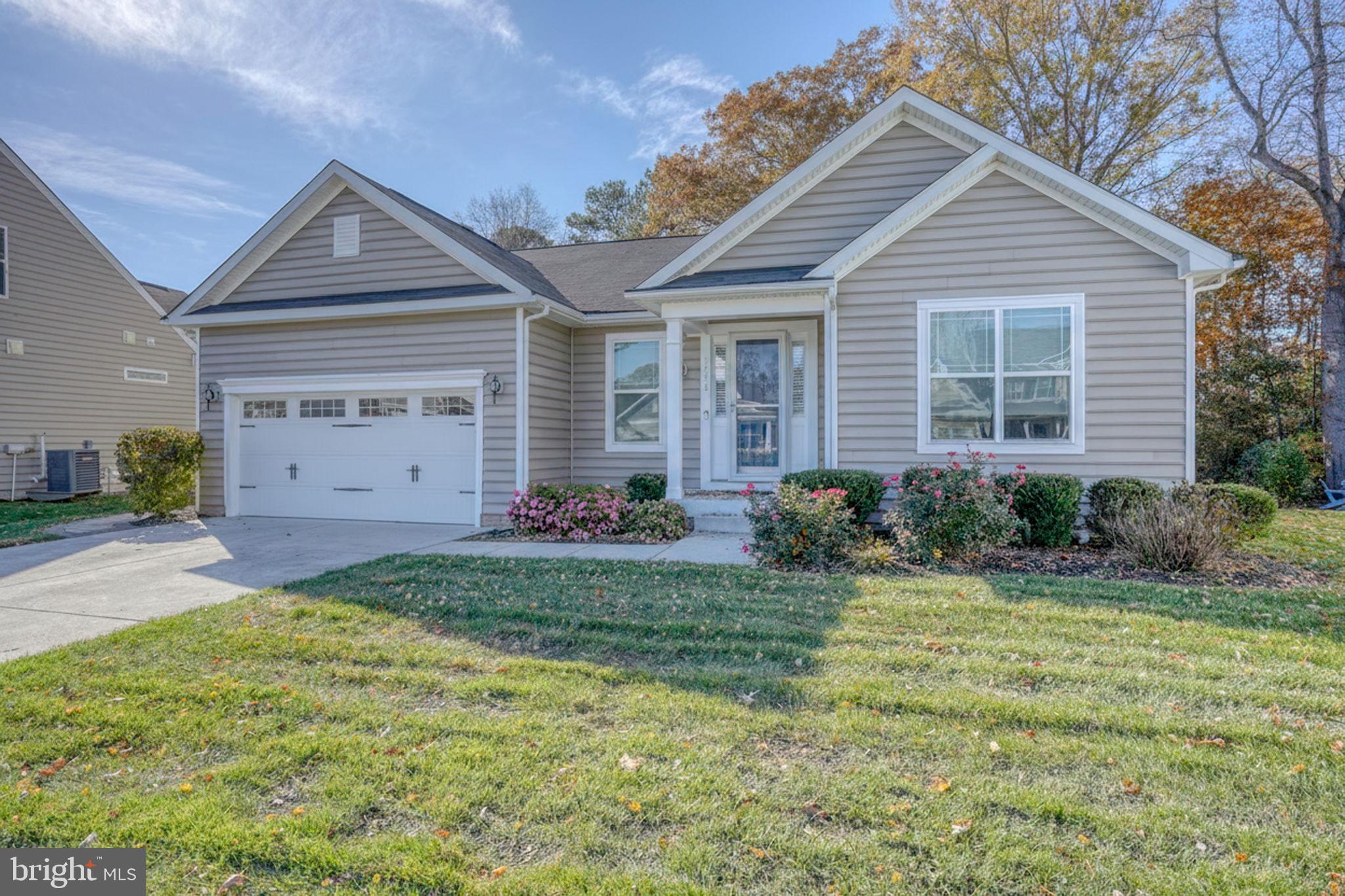 34273 Spring Brook Avenue Lewes, DE 19958 - Photo 36 of 73 a front view of a house with a yard and garage