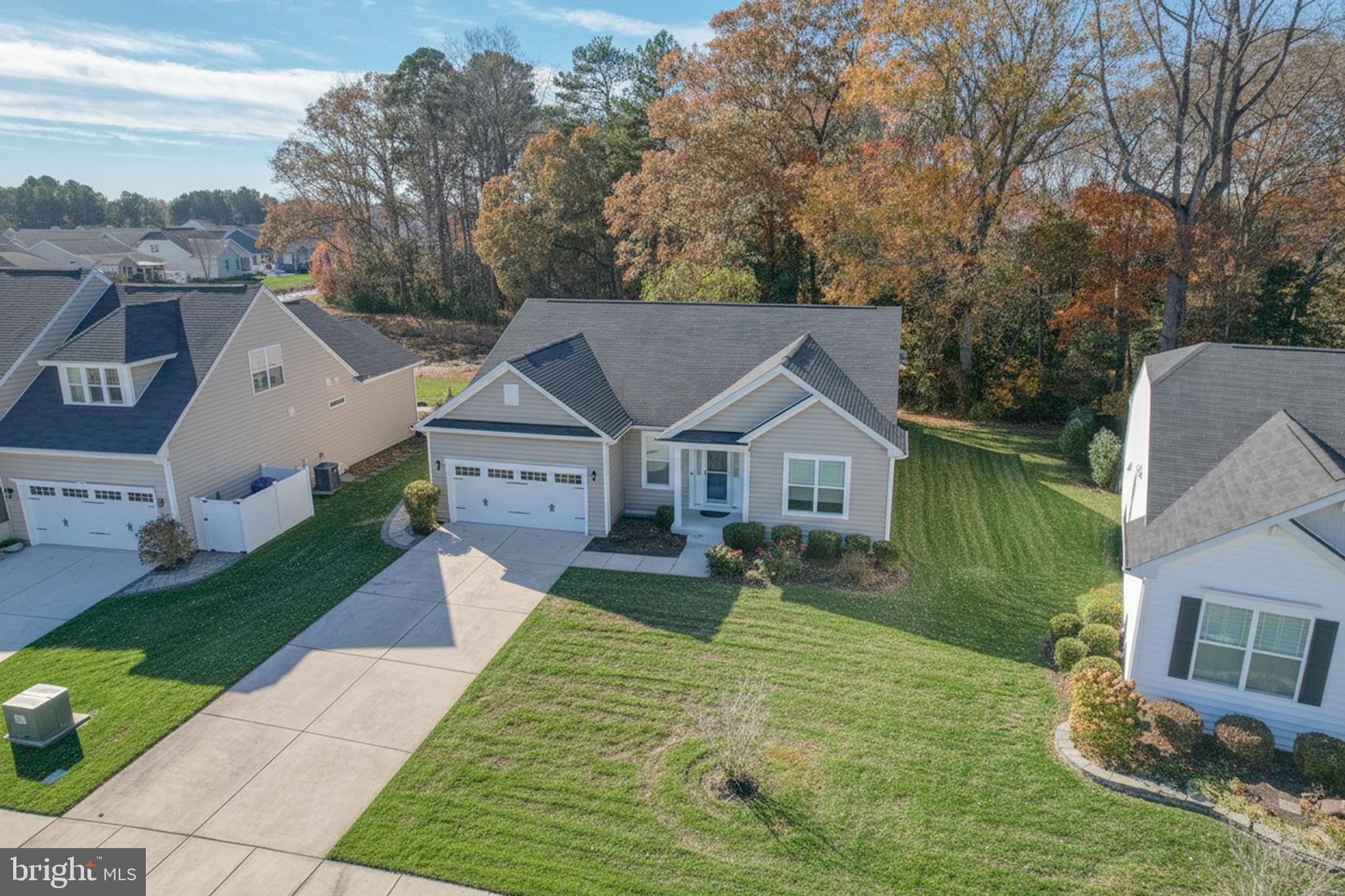 34273 Spring Brook Avenue Lewes, DE 19958 - Photo 42 of 73 a front view of a house with a yard and garage