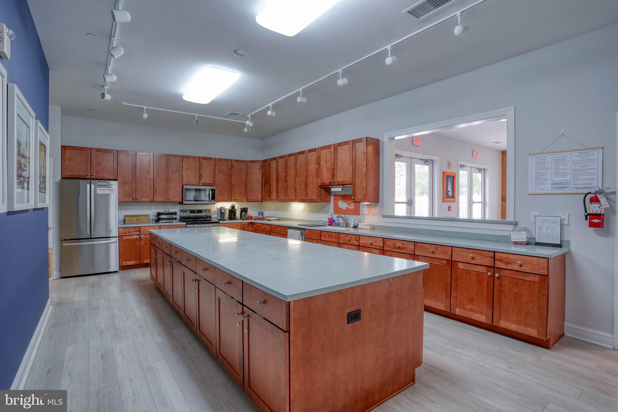 34273 Spring Brook Avenue Lewes, DE 19958 - Photo 57 of 73 a kitchen with stainless steel appliances granite countertop a table chairs sink and cabinets