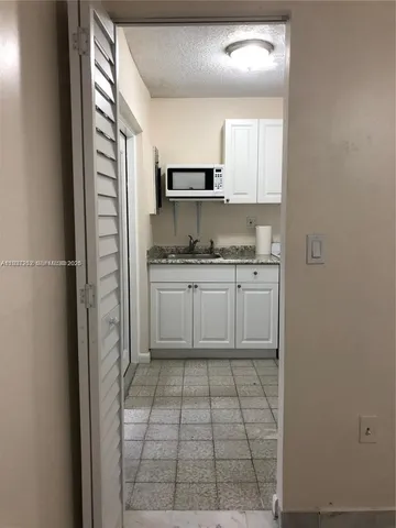 a kitchen with a sink a refrigerator and cabinets