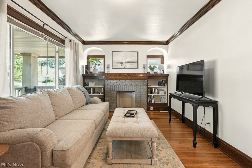 3579 Bosworth Road Cleveland, OH 44111 - Photo 22 of 39 Living area featuring hardwood flooring, a stone fireplace with wood mantel, built-in shelving, and large sliding glass doors