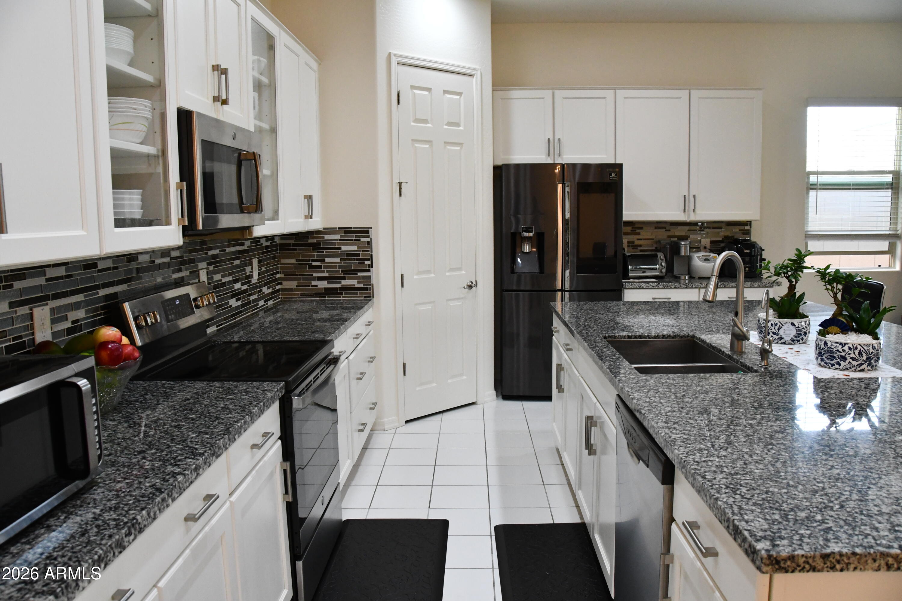 22419 97th Lane Peoria, AZ 85383 - Photo 4 of 22 a kitchen with stainless steel appliances granite countertop a sink stove and refrigerator