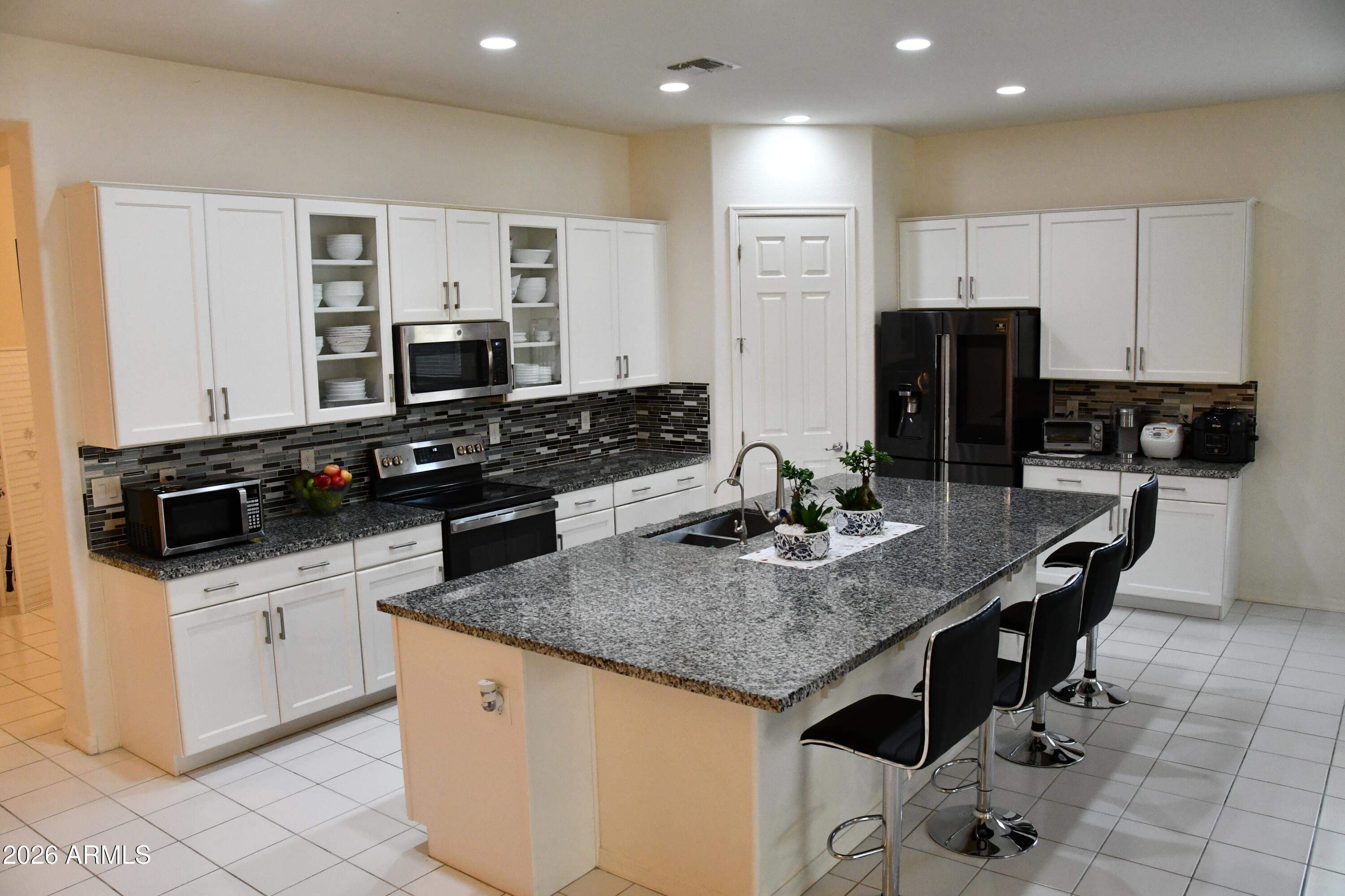 22419 97th Lane Peoria, AZ 85383 - Photo 6 of 22 a kitchen with stainless steel appliances granite countertop a stove a sink a microwave a refrigerator and cabinets