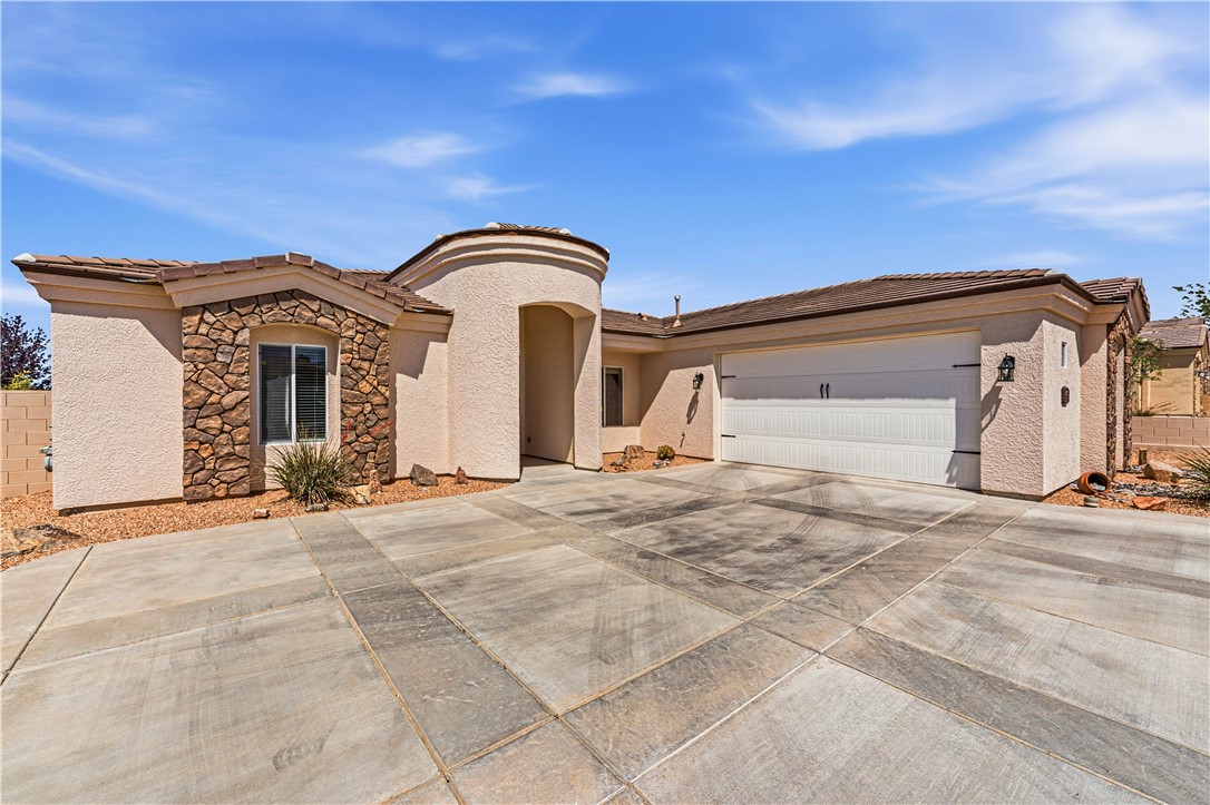 3315 Rainbow Mine Road Kingman, AZ 86401 - Photo 50 of 54 The property features a stucco exterior with natural stone accents, a two-car garage, and a concrete driveway