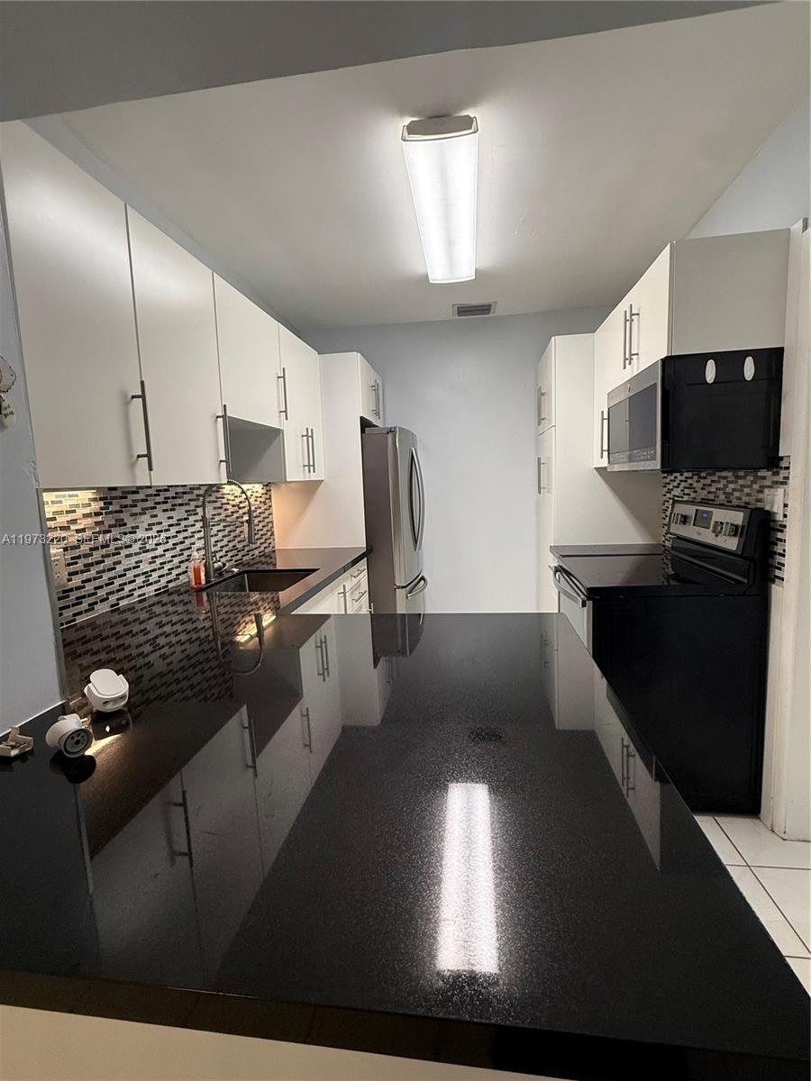 4255 Southwest 5th Terrace Miami, FL 33134 - Photo 8 of 29 a kitchen with stainless steel appliances a refrigerator and a microwave