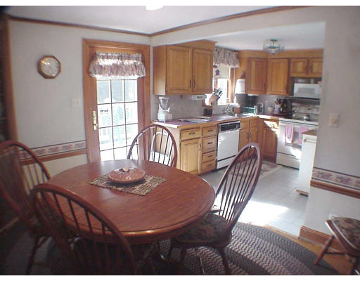 23 Virginia Road Arlington, MA 02476 - Photo 3 of 7 a kitchen with granite countertop a stove a sink a dining table and chairs