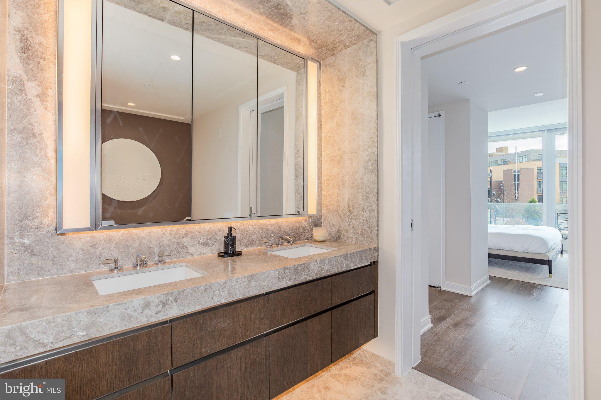 601 Wharf Street Southwest, Unit 203 Washington, DC 20024 - Photo 16 of 34 a en suite bathroom with a granite countertop sink and a mirror