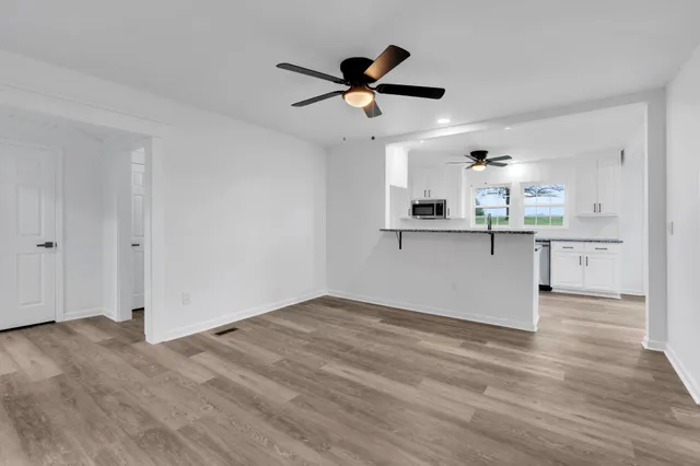 a view of a kitchen with a sink and wooden floor