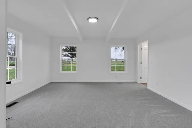 an empty room with windows and closet