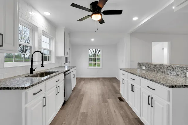 a kitchen with granite countertop cabinets stainless steel appliances a sink and a window