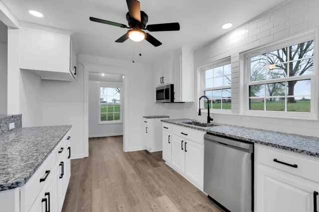 a large kitchen with a lot of counter space and wooden floor