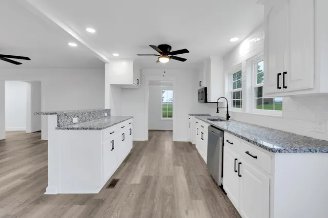 a kitchen with a sink cabinets a window and stainless steel appliances