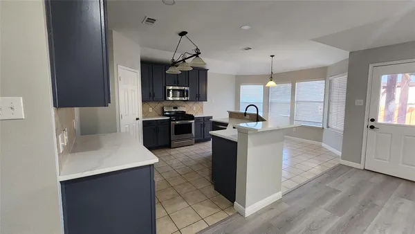 a kitchen with kitchen island a sink stainless steel appliances and cabinets