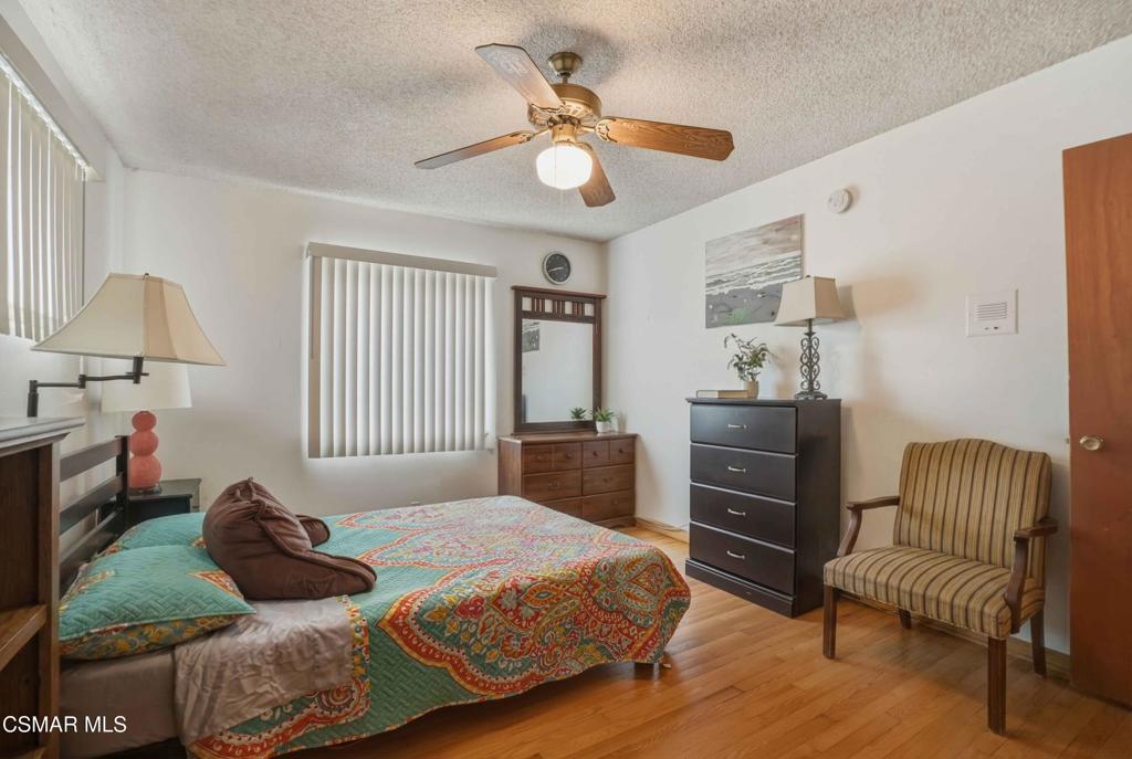 558 East Hemlock Street Oxnard, CA 93033 - Photo 7 of 22 a bedroom with a bed and a chandelier