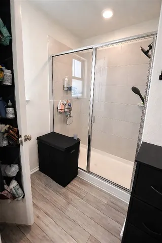 a living room with a black floor to ceiling window and wooden floor