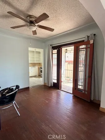 a view of an empty room with a window and wooden floor
